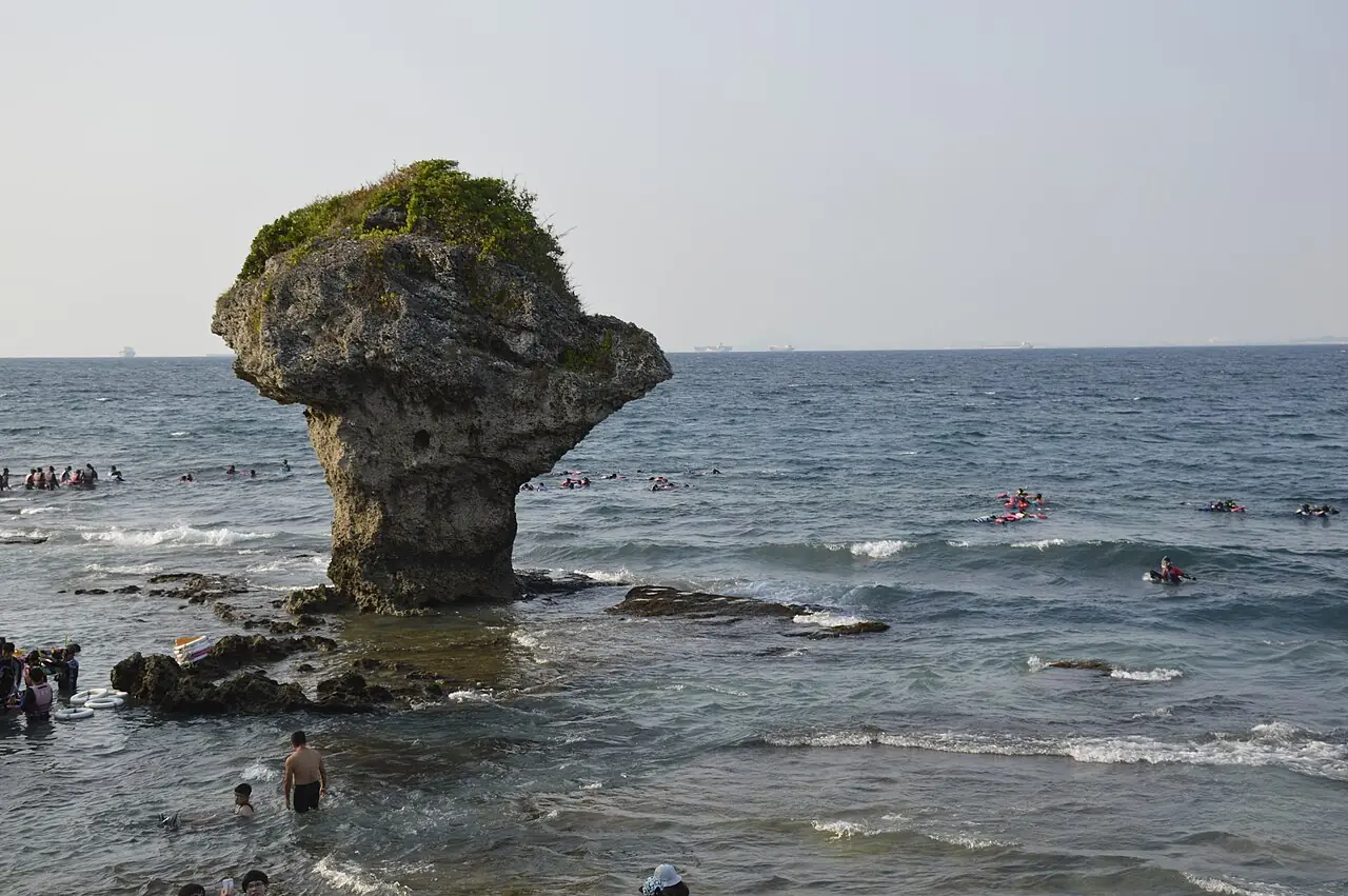 小琉球的花瓶岩與在旁邊戲水的遊客